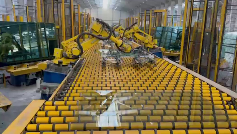 Robotic arm handling glass sheets on a production line