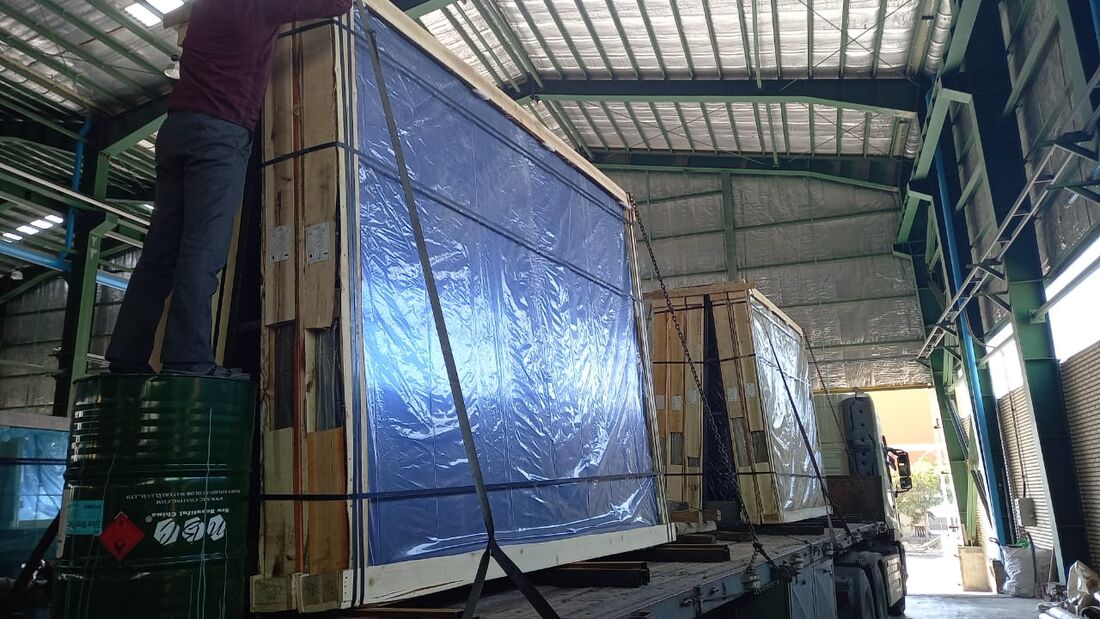 Packaged glass sheets staged in warehouse for shipment